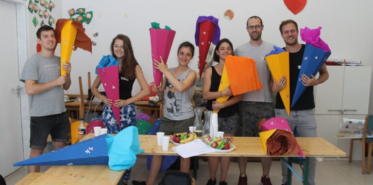 Six people posing with their colourful handicrafted candy cones
