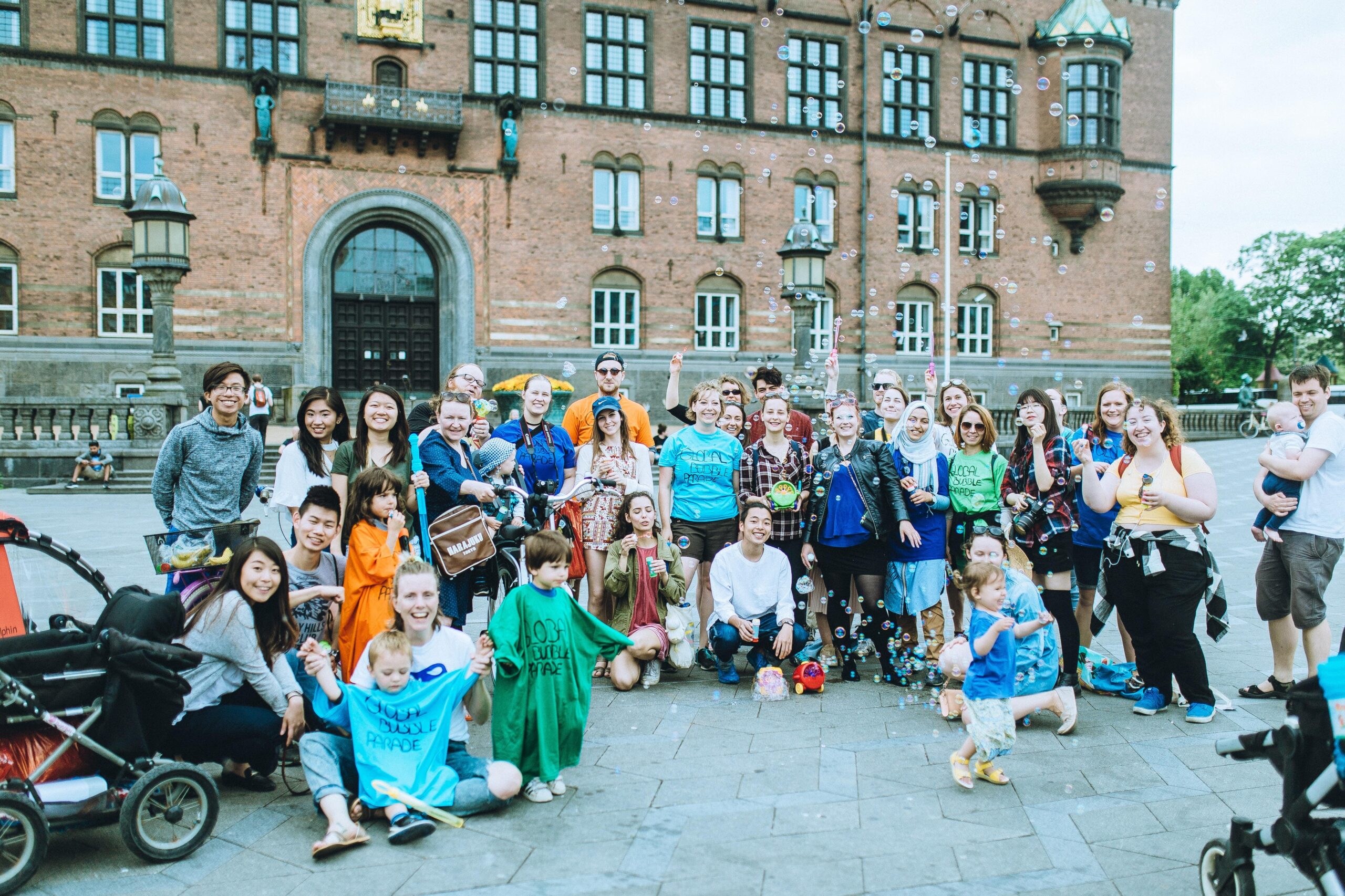 Many people with children in front of a castle with soap bubbles