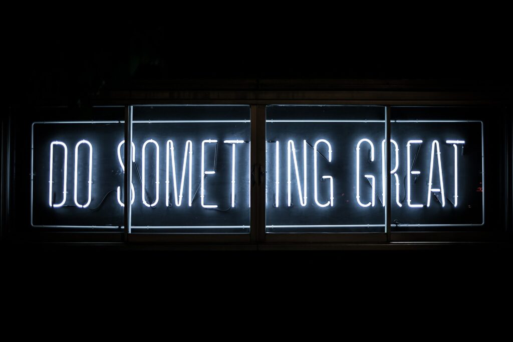 sign in the dark saying in blue colour Do Something Great
