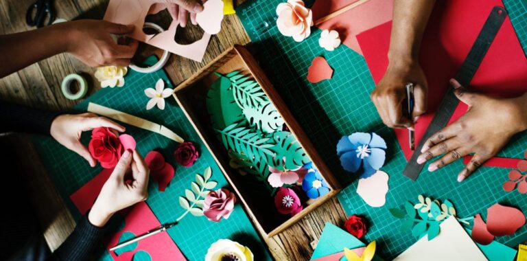 hands cutting colourful flowers out of paper