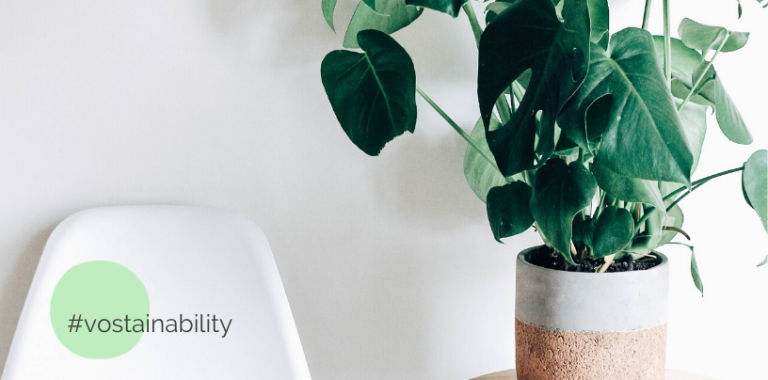 Weißer Stuhl mit #vostainability Schriftzug. Daneben eine Pflanze