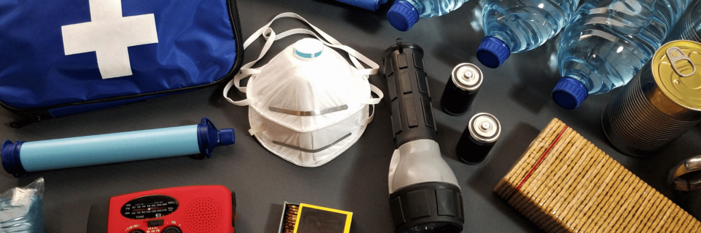 verschiedene Gegenstände zur Erstversorgung – z.B. Erste-Hilfe-Kasten, Masken, Batterien, Wasser und mehr