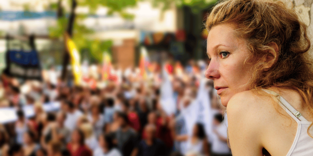 Frau schaut über eine Menschenmenge bei einer Demonstration für Demokratie