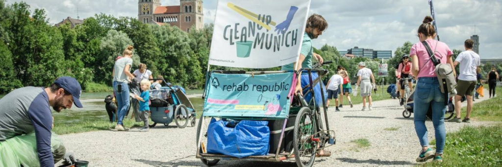 Menschen auf einem Cleanup in München sammeln Müll auf einem Weg