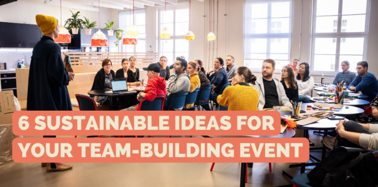 Woman explains work tasks, to a big group of people in a hall.