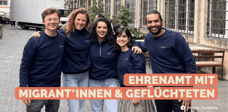 Eine Gruppe aus 5 jungen Menschen unterschiedlicher Hingergründe stehen zusammen und posieren für das Foto