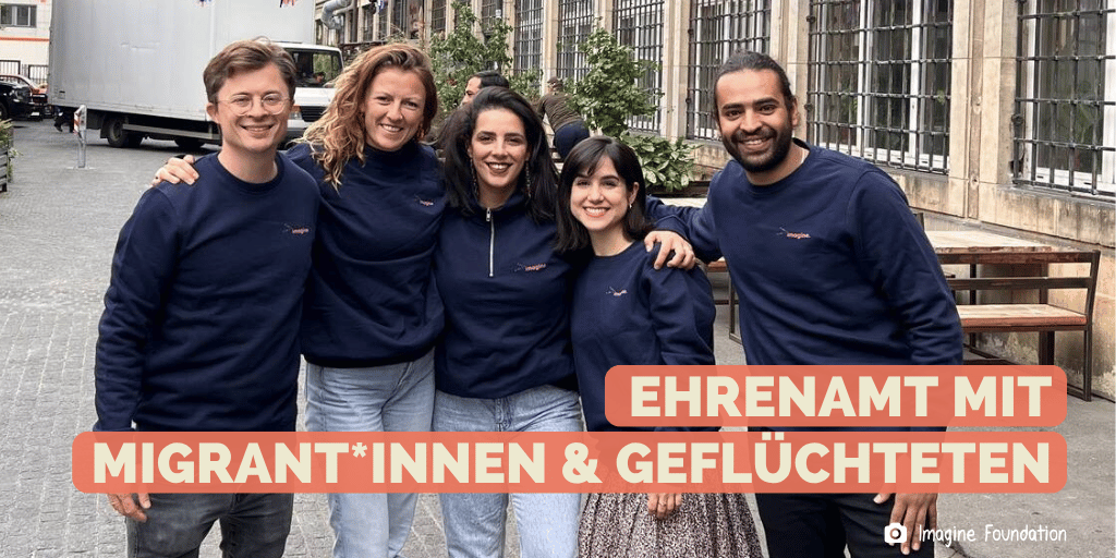 Eine Gruppe aus 5 jungen Menschen unterschiedlicher Hingergründe stehen zusammen und posieren für das Foto