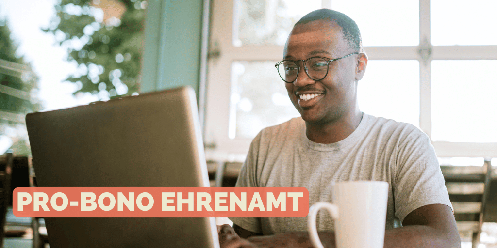 Mann sitzt vor einem Laptop und scheint sich zu freuen